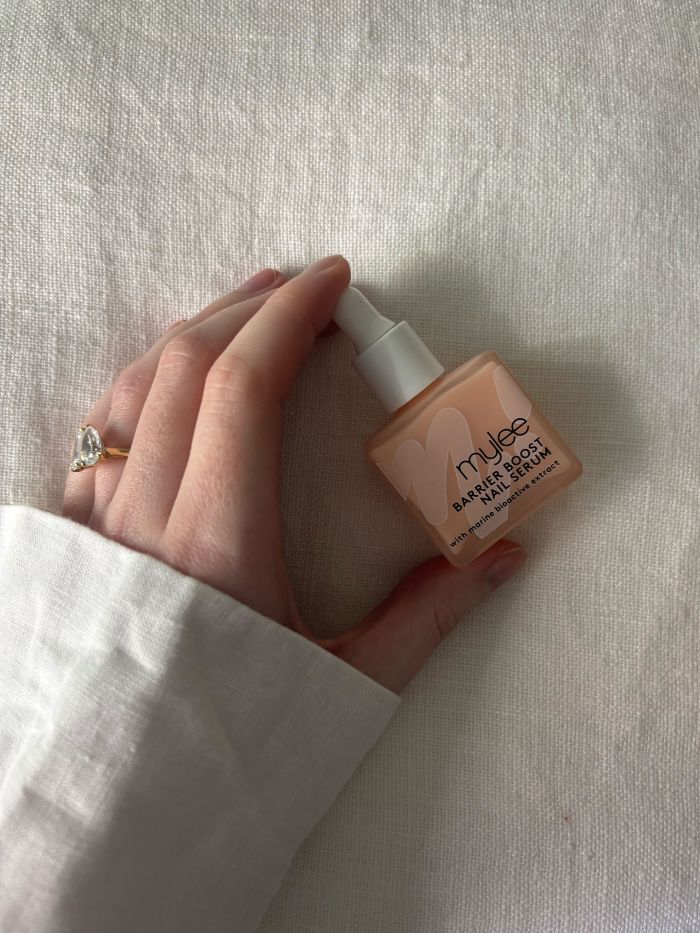 Deputy Beauty Editor Grace Lindsay holding Miley Barrier Boost Nail Serum