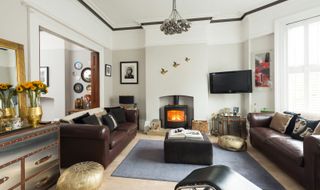 a living room with a log burner and tv in an alcove