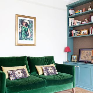 living room with velvet sofa cushions and photo frame on wall