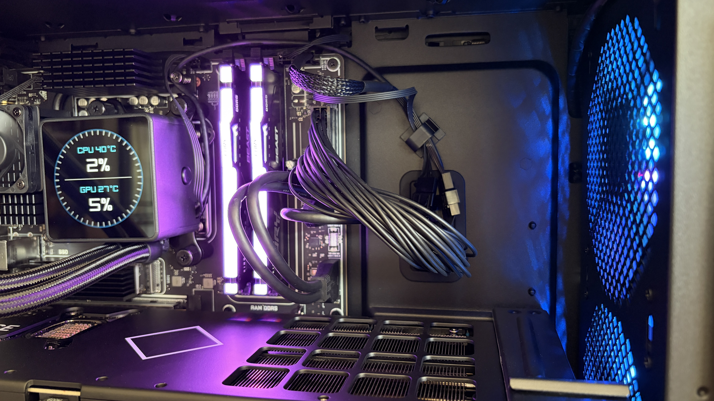 Interior of an Omen Max 45L computer case featuring a liquid cooling unit with temperature readings, illuminated RAM sticks, and blue lighting from a fan.