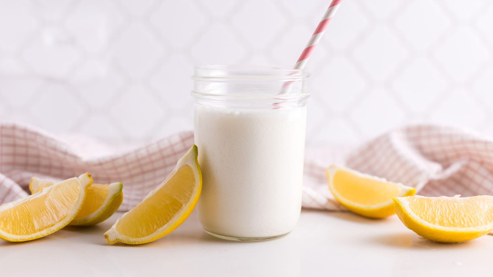 Creamy lemon drink in a mason jar with a stripy straw