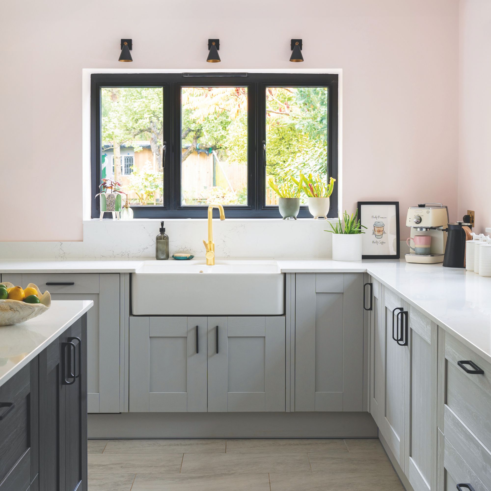 Pink painted kitchen with grey cabinets and a white worktop