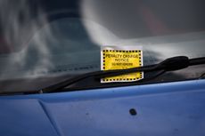 Parking ticket on windshield of car left by a traffic warden working in lockdown