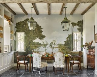 A dining room with a pastoral mural, antique lanterns and mahogany dining suite