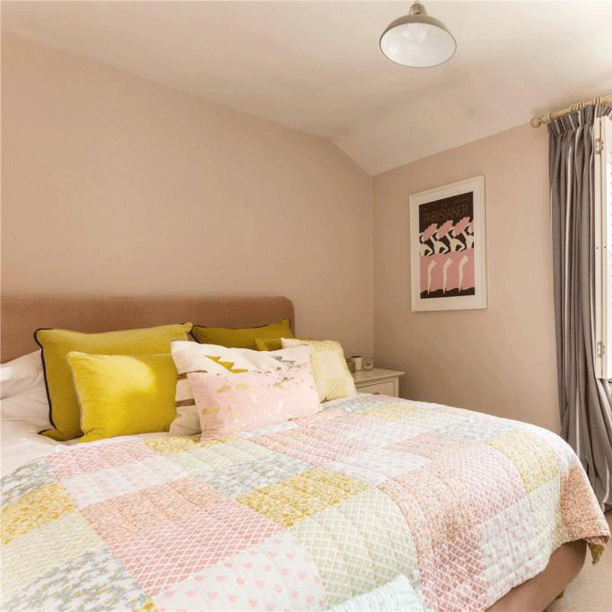 guest bedroom with pink wall and bed