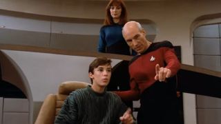 Captain Jean-Luc Picard showing a young Wesley Crusher around the bridge of the USS Enterprise. Dr. Beverly Crusher, Wesley's mother, is standing in the background.