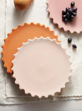 two scalloped dinner plates on a table