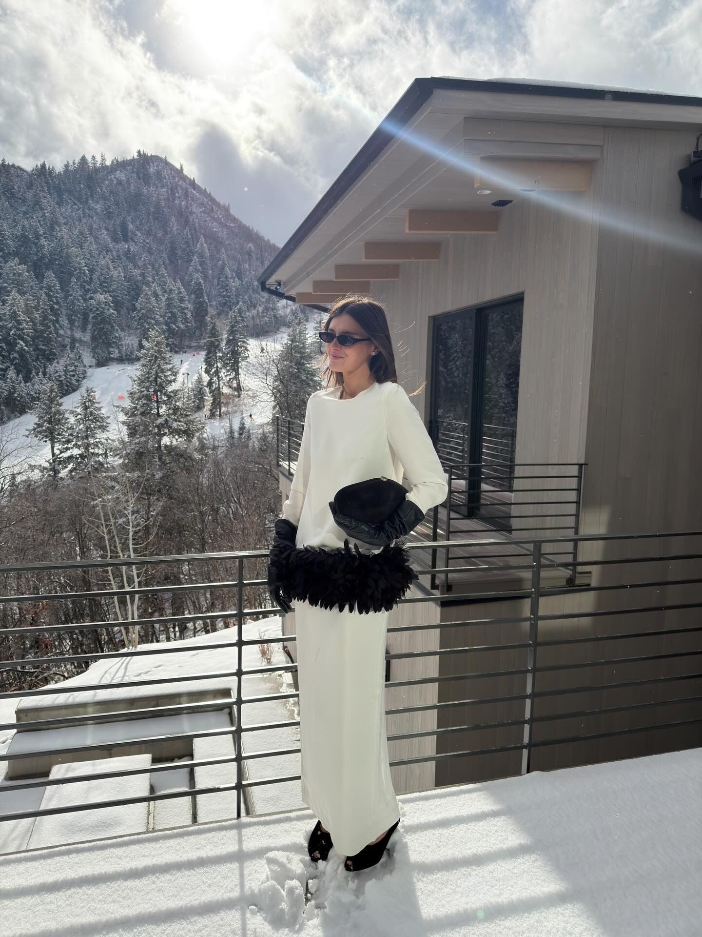 Coco wears a white dress with black feather and black leather gloves.
