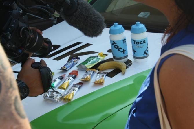 A TV crew films the contents of a Team Belkin musette &ndash; this lucky rider has a Frosties bar bar coming his way