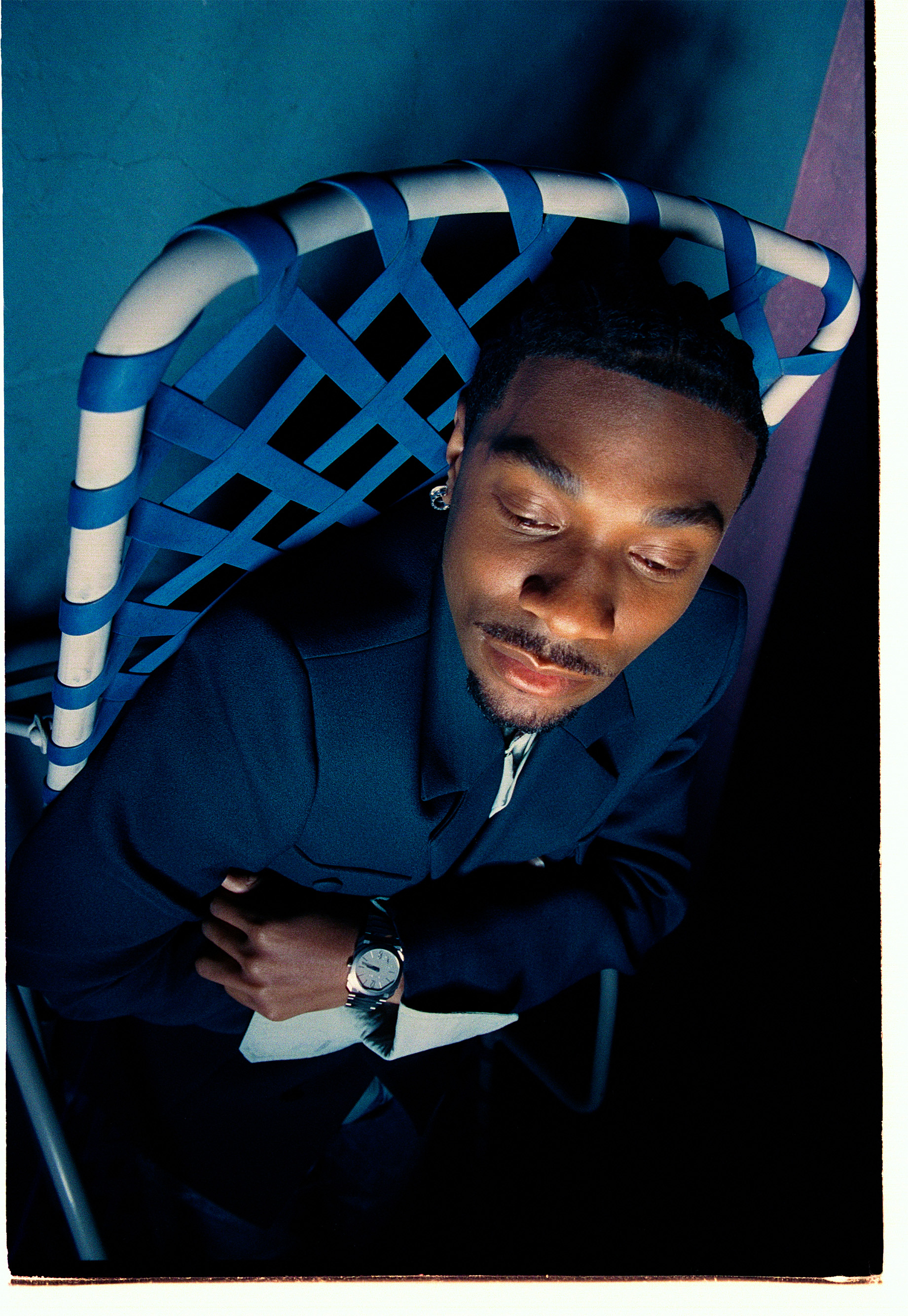 Jonathan Daviss wearing a suit and watch while sitting on a net chair.