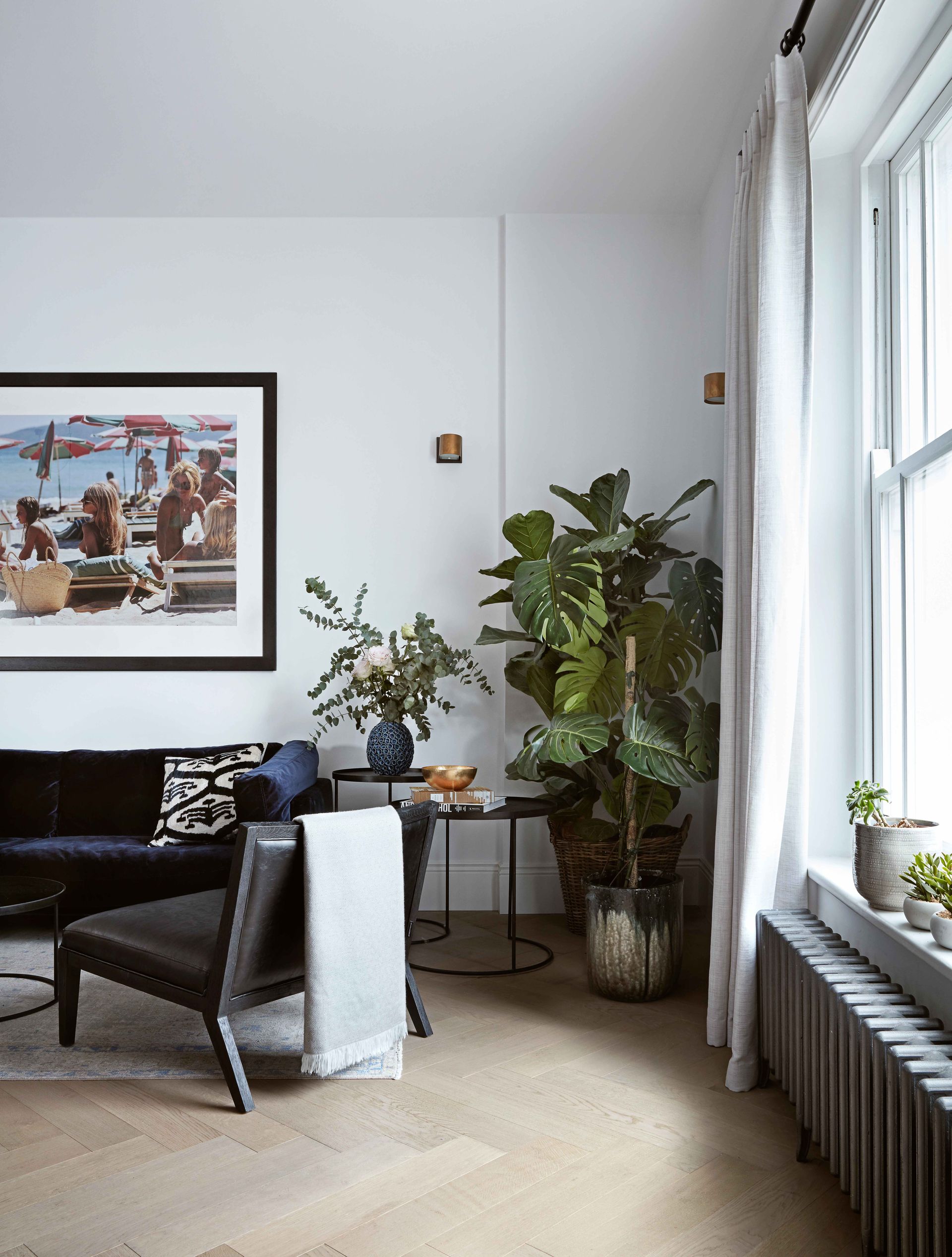 White modern living room with houseplants and artwork