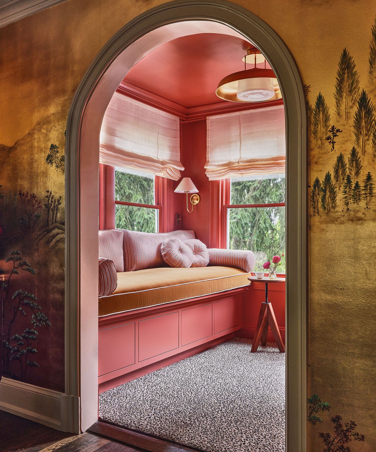 pink reading room with daybed seen through an arched doorway