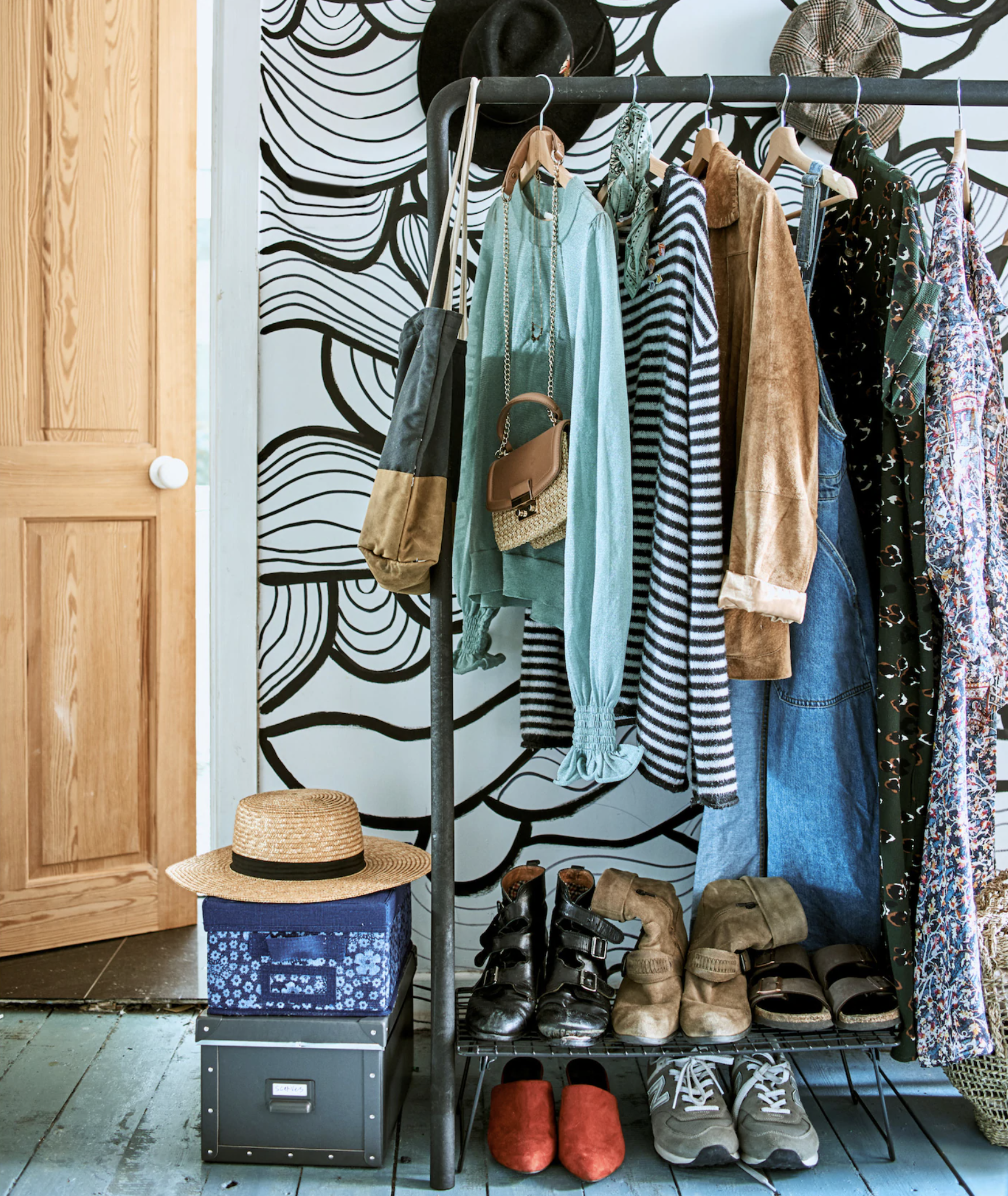a clothes rail in a bedroom with a wooden door in the background