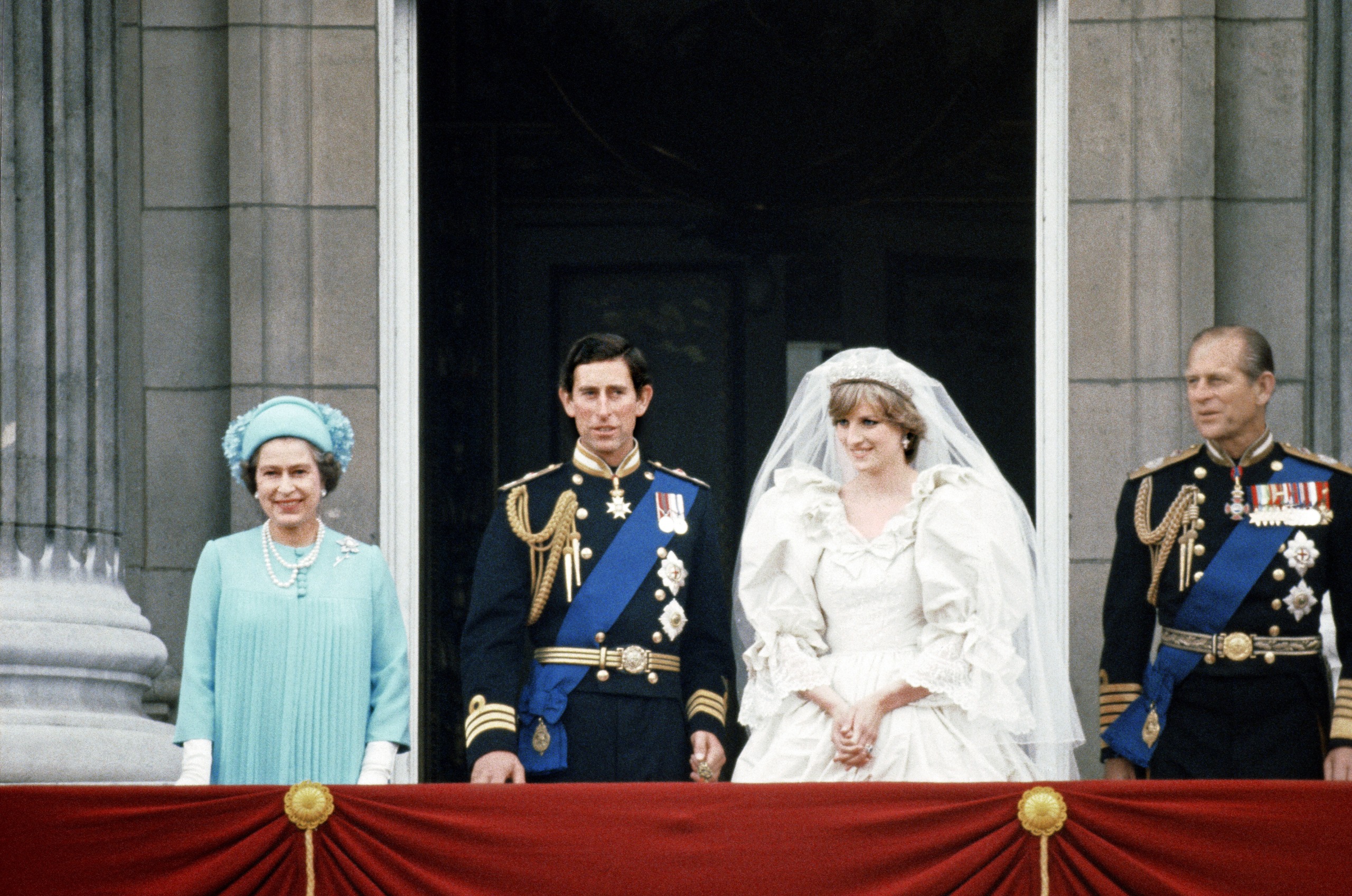Queen Elizabeth and Prince Philip standing with Prince Charles and Princess Diana on the balcony of Buckingham Palace on their wedding day