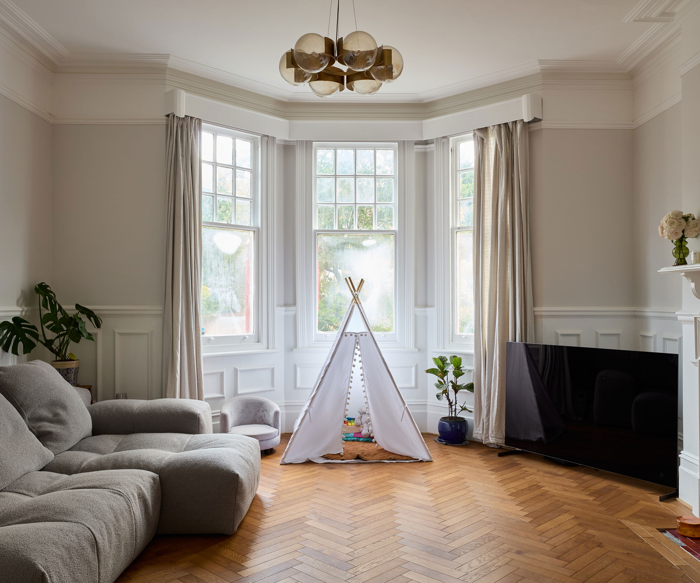 living room in period house with bay window and herringbone wooden flooring