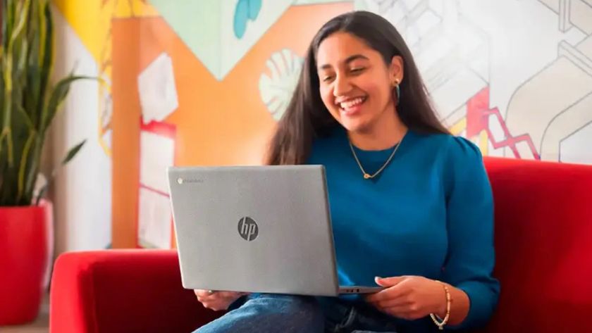 A woman sitting on a couch using an HP Chromebook