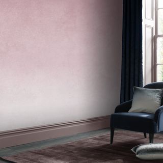 Pale pink wall, wooden floor and blue armchair