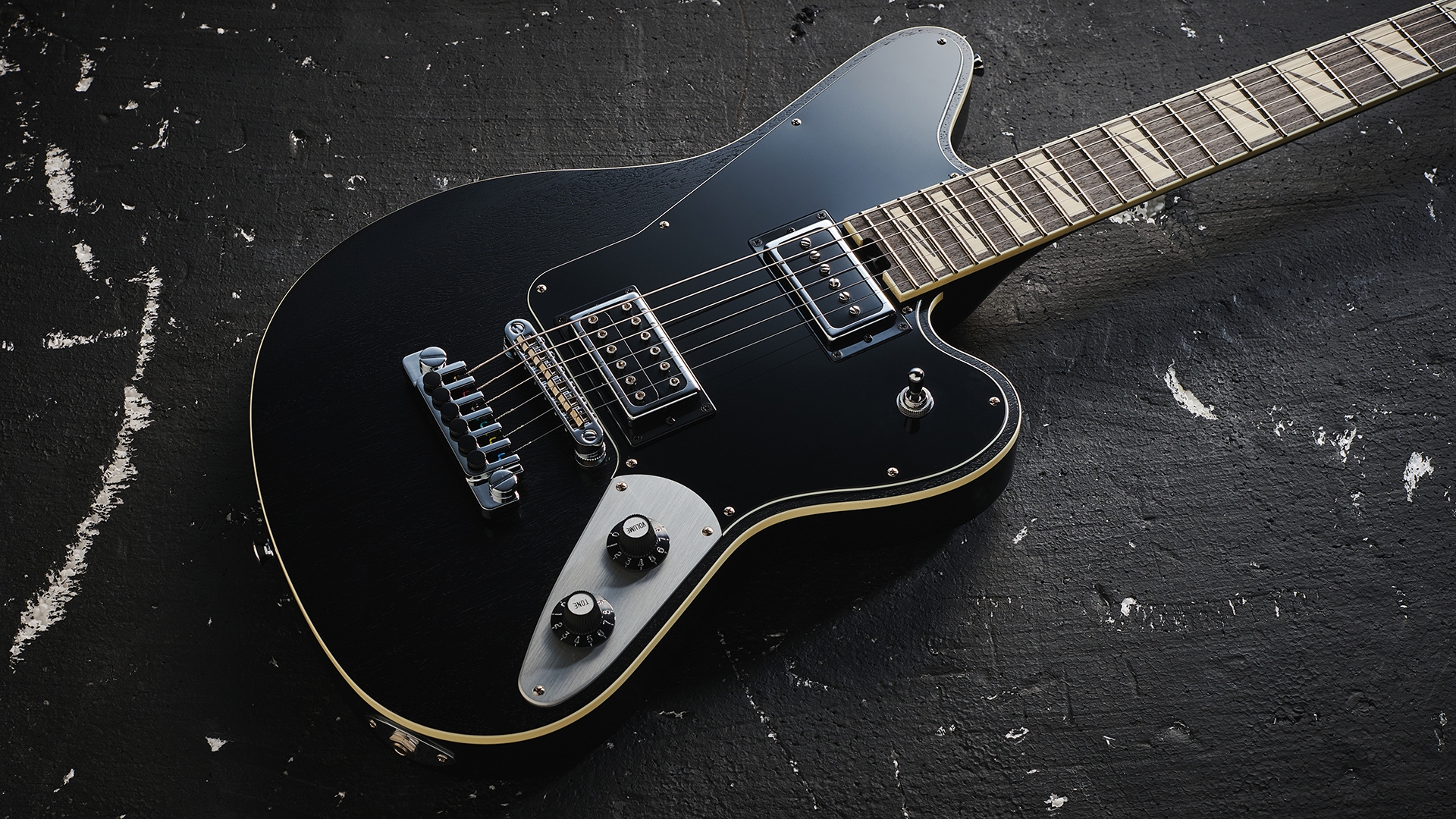 A Jackson Pro Series Lee Malia LM-87 electric guitar lying on a distressed black floor