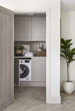 A laundry room with a washing machine and built in cabinetry
