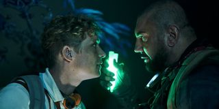 Matthias Schweighöfer and Dave Bautista talk by the light of glow stick in Army of the Dead.