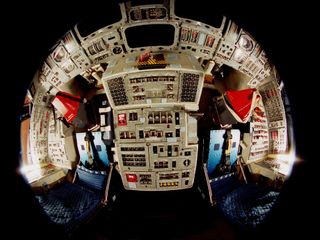 This fish-eye view shows off Discovery's cockpit as it was configured for the STS-95 mission. Commander Curtis Brown's seat is on the left, while Pilot Steve Lindsey's seat is beside it on the right. This image was taken Oct. 13, 1998.
