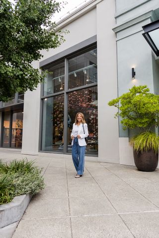 Woman wearing heels with jeans and a white blazer.