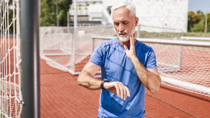 Senior athlete taking a break taking pulse