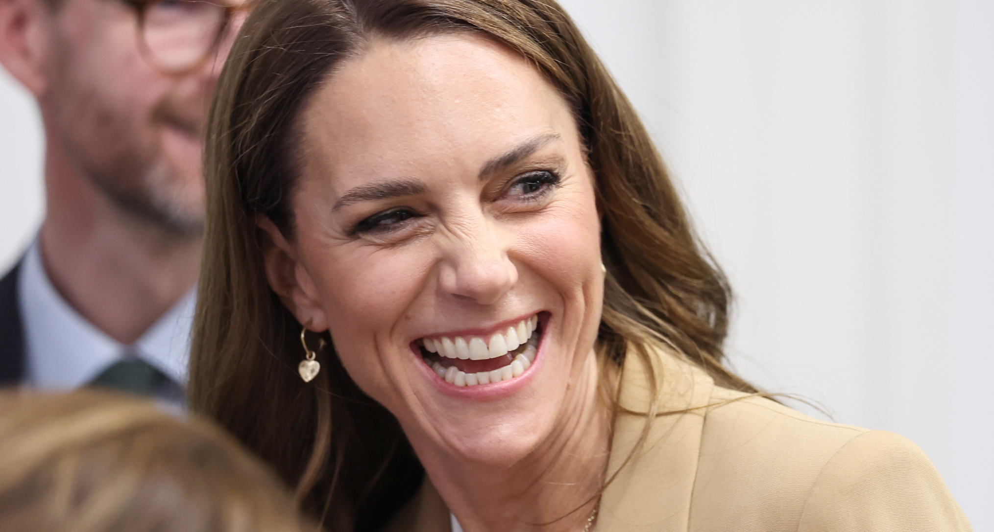 Princess Kate smiling in a tan blazer