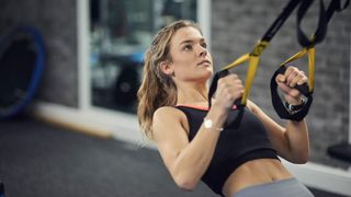 Woman uses the TRX to perform a row