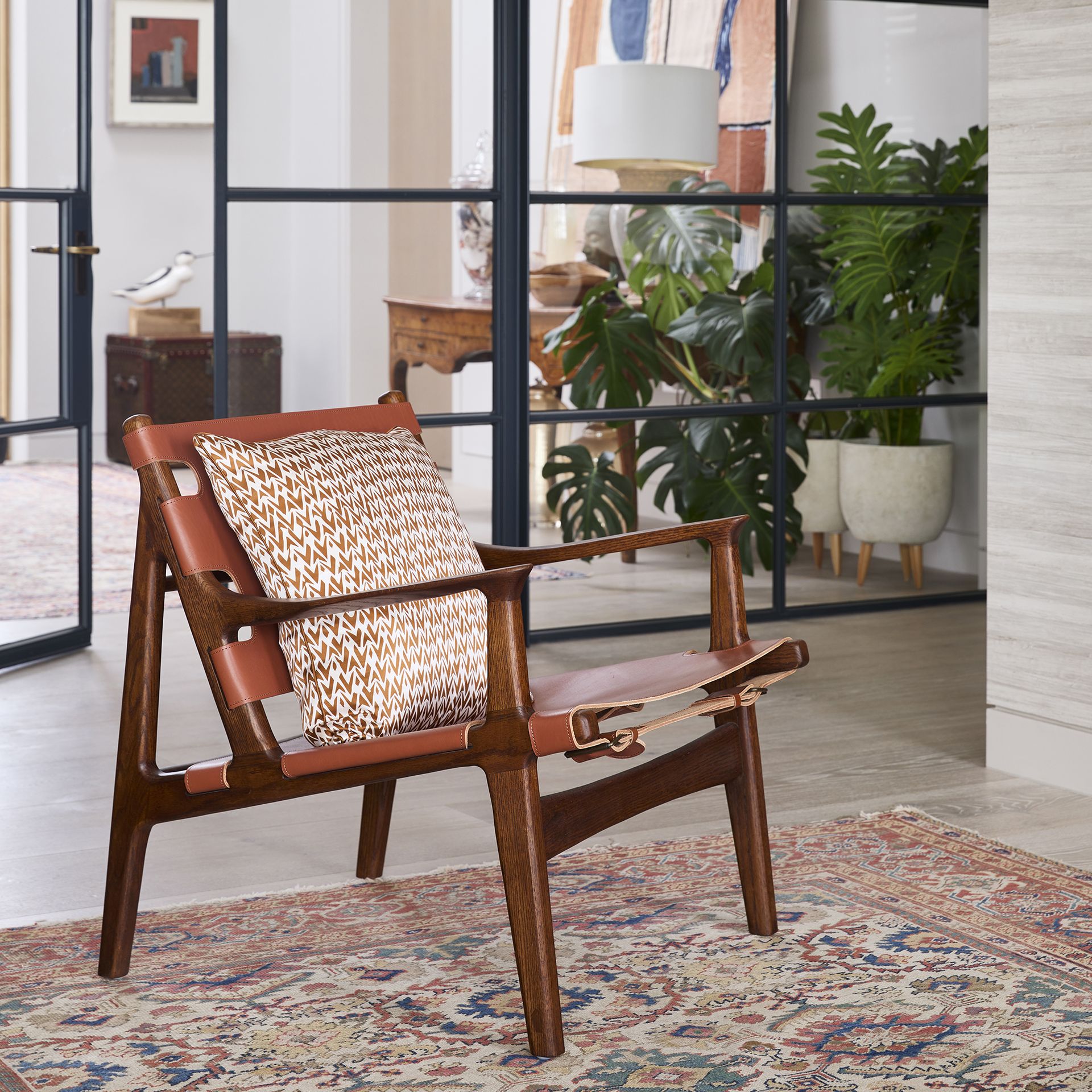Living room with crittall style doors and a mid-century armchair.