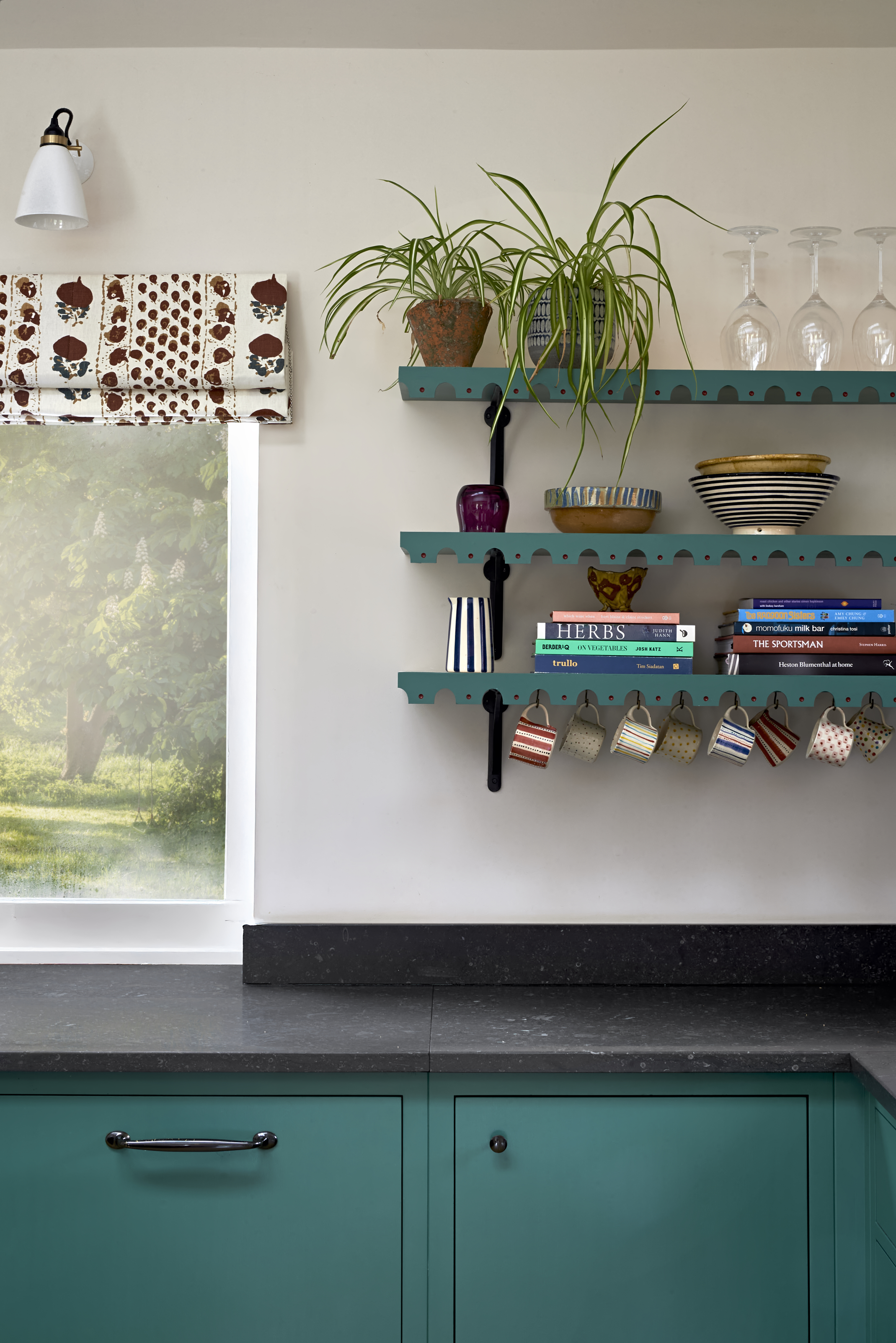 a kitchen in teal with shelves with a decorative edging