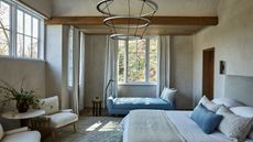 Neutral master bedroom with beams, large pendant and blue master bed