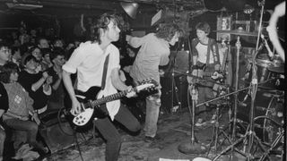 R.E.M. performs at The Rat in Boston. Band members include, left to right, Peter Buck, Michael Stipe, Mike Mill