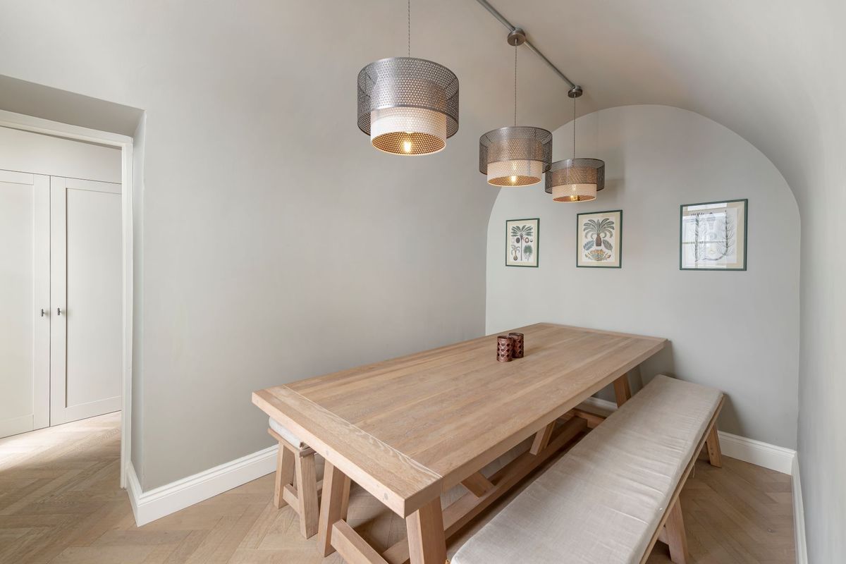 A dining room table and bench seats in a plainly decorated room