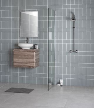 wet room with grey floor and wall tiles