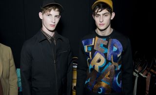 Two male models wearing casual clothing by Salvatore Ferragamo.