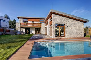 a self build home with a stone cladding exterior