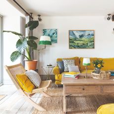 A bright living room with a yellow sofa with grey cushions