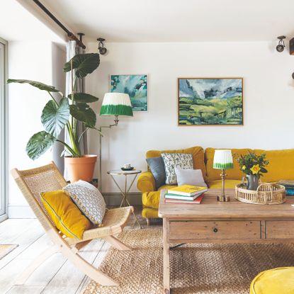 A bright living room with a yellow sofa with grey cushions