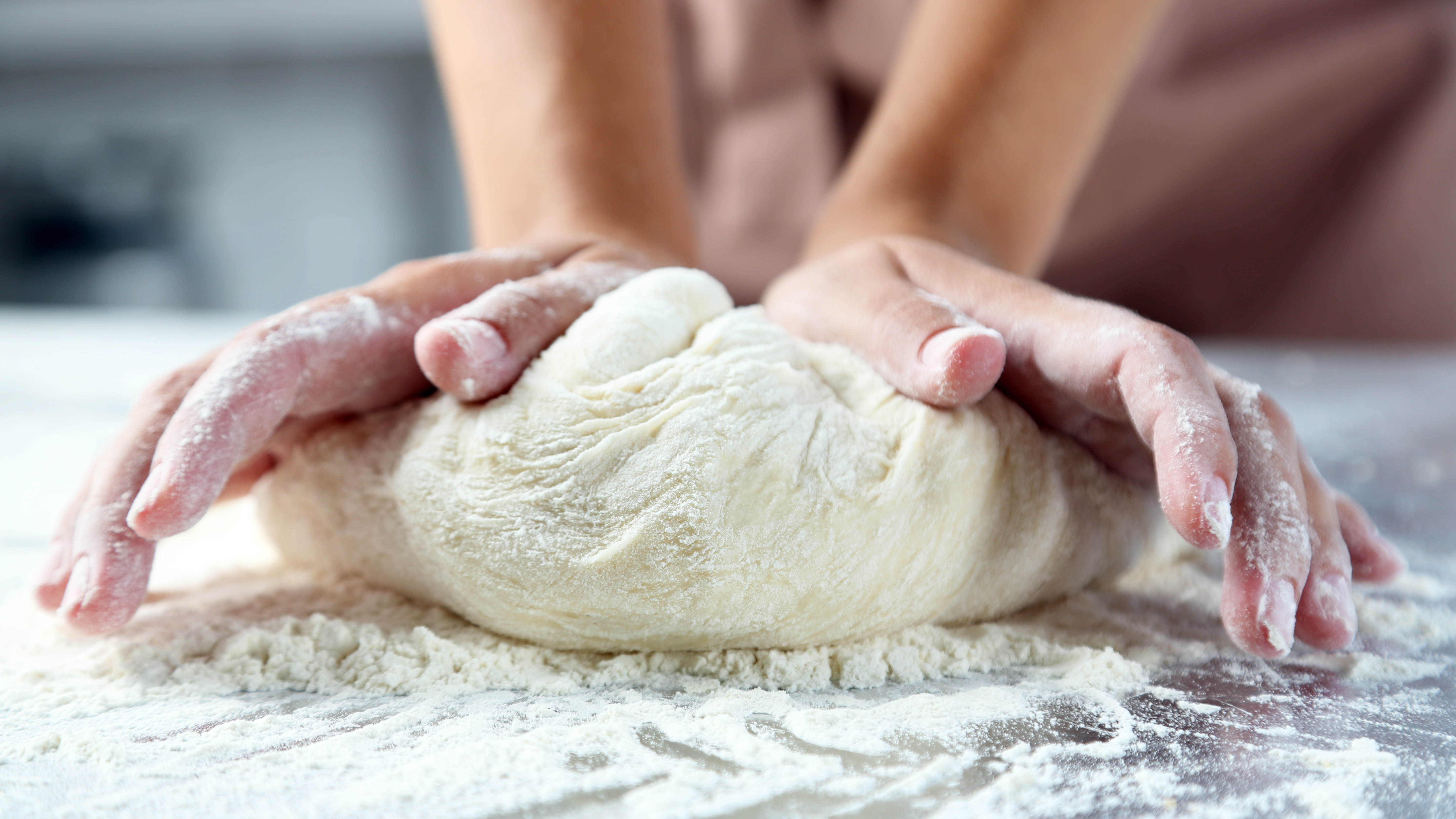 Из муки делают тесто. Месить тесто. Руки месят тесто. Замешивание теста. Вымешиваем тесто руками.