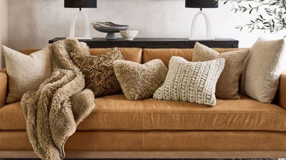 Some of the best bouclé pillows from Pottery Barn on a leather sofa