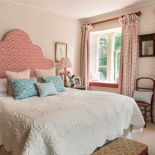 Country style bedroom with a mix of patterned fabrics and wallpaper