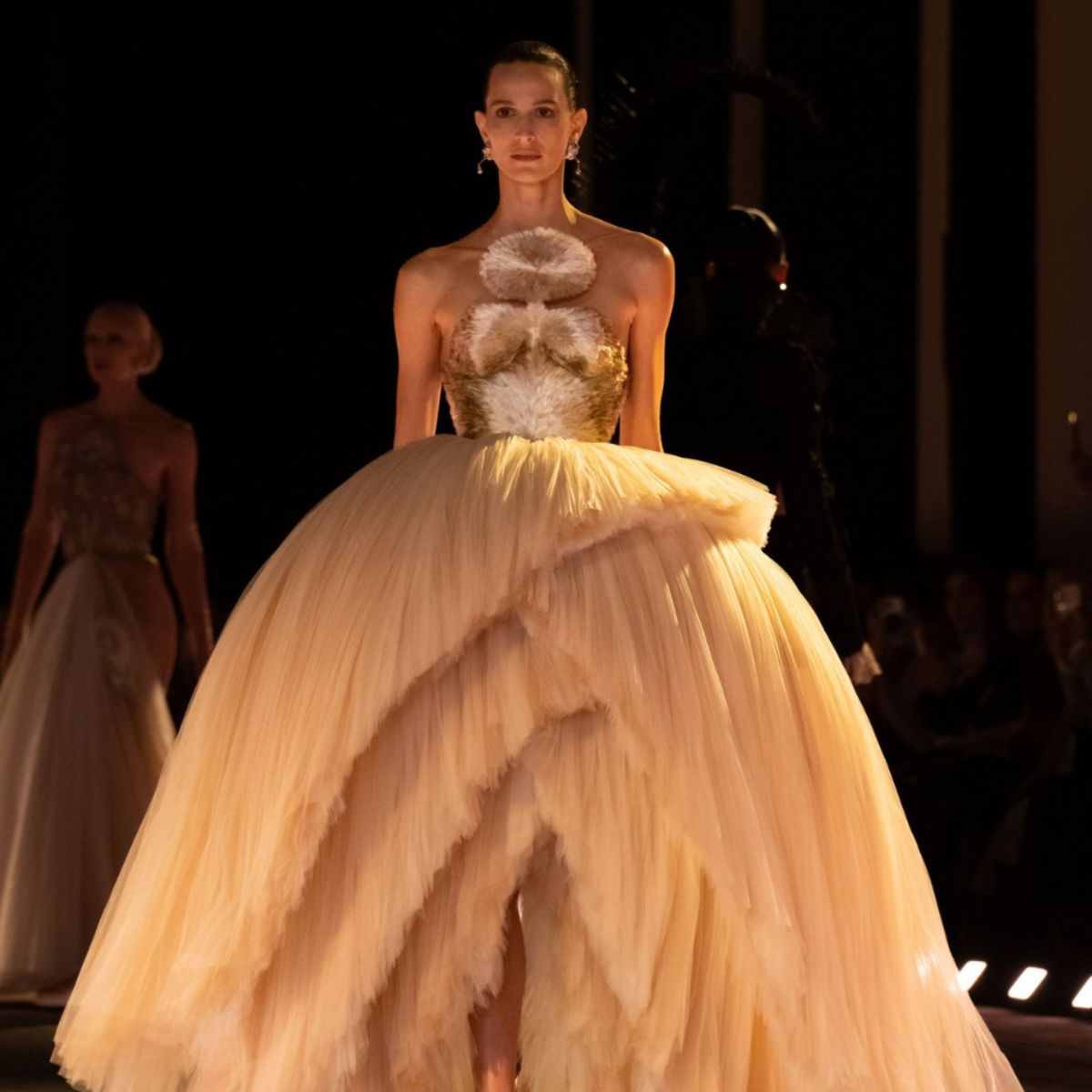 a model wears a dramatic gown at the schiaparelli ss26 show