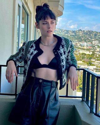 Kristen Stewart wearing a cardigan open over a black Fleur Du Mal bra