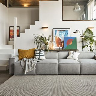 white living room with grey sofa and paintings