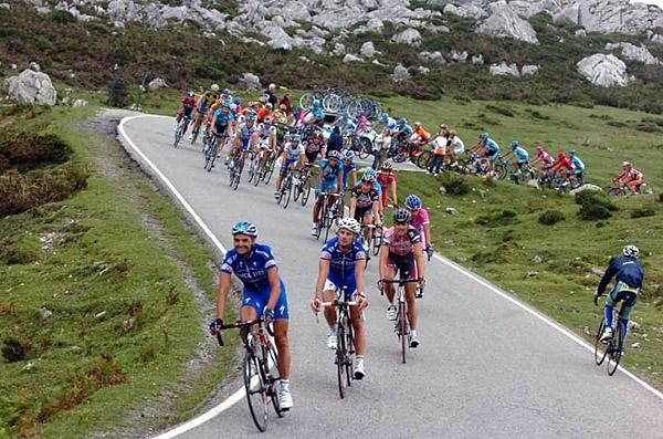 The autobus climbs to the finish while riders having already completed the stage descend