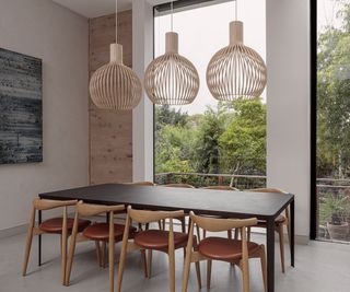 Scandinavian dining room with a dark table and wooden wishbone chairs