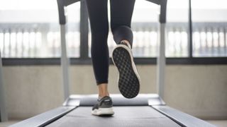 View of woman's feet on treadmill, doing walking intervals at the gym