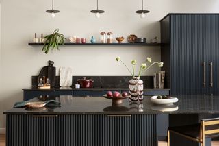 a fluted black kitchen with eclectic worktop decor