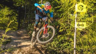 A mountain biker jumps off a rock using one of the best budget mountain bike forks from Marzocchi